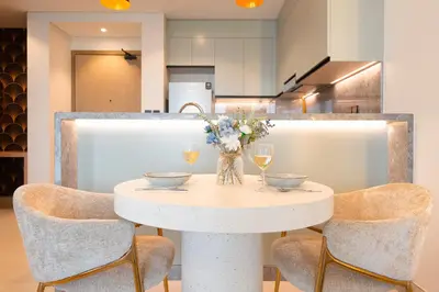 a white table with chairs and glasses of wine at KeyRock Living - Golf Gate Apt with Pool Access in Dubai