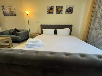 a bedroom with a large bed and a couch at Furnished Studio in JVC Hassle-Free Living in Dubai