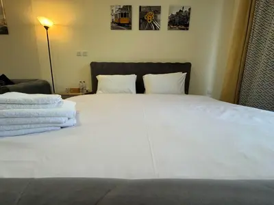 a bedroom with a bed with white sheets and pillows at Furnished Studio in JVC Hassle-Free Living in Dubai