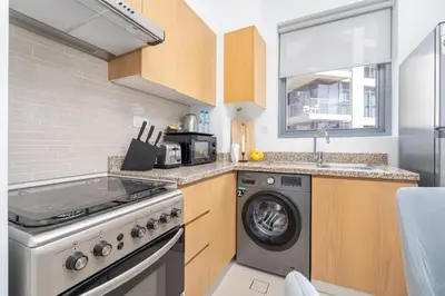 a kitchen with a washing machine and a washer at Vogue Downtown Bellevue Towers near Burj Khalifa and Dubai Mall, One Bedroom Apartment with City View, Full Access to all Amenities in Dubai