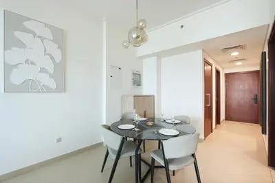 a dining room with a black table and white chairs at Prime Located 2BR Near Burj Khalifa & Dubai Mall in Dubai