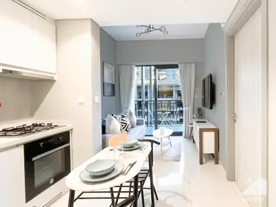 a kitchen and living room with a table and chairs at Wonderful Stay at Zada Tower l 1BR with Balcony in Dubai