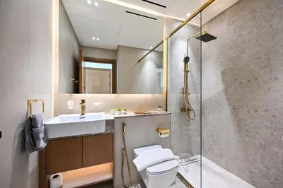 a bathroom with a shower and a toilet and a sink at Golden Stays - Binghatti Amber I Luxury 1BR Apartment I Fully Furnished I Pool & Gym in Dubai