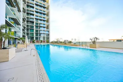a large swimming pool in the middle of a building at Golden Stays - Binghatti Amber I Luxury 1BR Apartment I Fully Furnished I Pool & Gym in Dubai