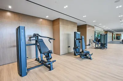 a gym with treadmills and ellipticals in a room at Golden Stays - Binghatti Amber I Luxury 1BR Apartment I Fully Furnished I Pool & Gym in Dubai