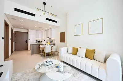 a living room with a white couch and a table at Golden Stays - Binghatti Amber I Modern 1BR Apartment I Balcony, Pool & Gym Access in Dubai