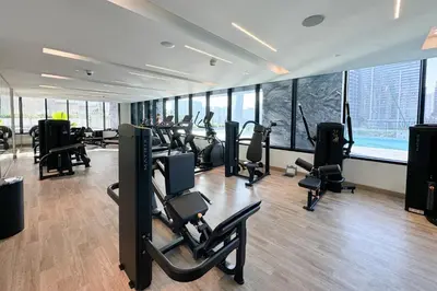 a gym with treadmills and ellipticals in a room with windows at Comfortable 2 Bedroom in Business Bay in Dubai
