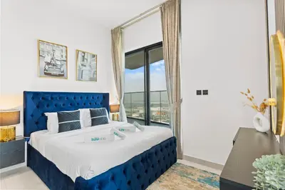 a blue bed in a room with a large window at Comfortable 2 Bedroom in Business Bay in Dubai