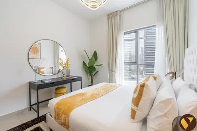 a white bedroom with a bed and a mirror at Vogue Downtown Bellevue Towers near Burj Khalifa and Dubai Mall, One Bedroom Apartment with City View, Full Access to all Amenities in Dubai