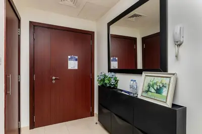 a hallway with a door and a mirror at Lovely 1BR Apartment Bahar 6 JBR in Dubai