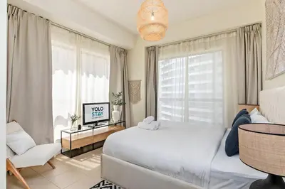 a bedroom with a large white bed and a window at Lovely 1BR Apartment Bahar 6 JBR in Dubai