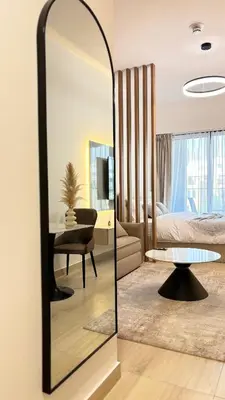 a mirror in a room with a bedroom at Best Sunrise Holiday Home in Dubai