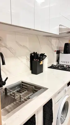 a kitchen counter with a dishwasher and a stove at Best Sunrise Holiday Home in Dubai