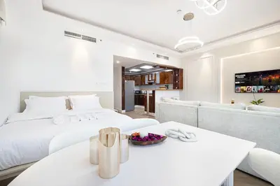 a white bedroom with a bed and a table at Lux 3BHK in Marina with Pool Table Opal 305 in Dubai