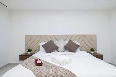 a bedroom with a white bed with towels on it at Lux 2BHK w Marina view w Sky Light Mesk 2007 in Dubai
