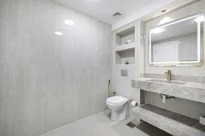 a bathroom with a toilet and a sink and a mirror at Lux 2BHK w Marina view w Sky Light Mesk 2007 in Dubai