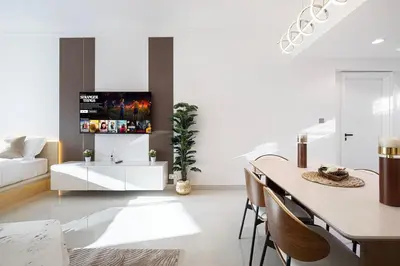 a living room with a table and a tv on a wall at Lux 2BHK w Marina view w Sky Light Mesk 2007 in Dubai