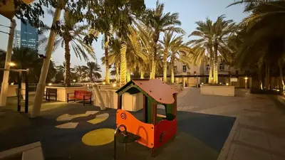 a small playground in a courtyard with palm trees at Lux 2BHK w Marina view w Sky Light Mesk 2007 in Dubai