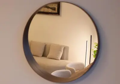a mirror reflection of a couch in a room at Luxury 2 BHK in Jumeirah By dPie Emaar 2008 in Dubai