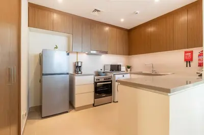 a kitchen with a stainless steel refrigerator and a sink at Luxury 2 BHK in Jumeirah By dPie Emaar 2008 in Dubai