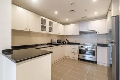 a kitchen with white cabinets and stainless steel appliances at Luxury 2BHK Stunning Skyline Lakeview in JLT 401 in Dubai