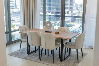 a dining room table and chairs with a view of a city at Luxury 2BHK Stunning Skyline Lakeview in JLT 401 in Dubai