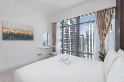 a bedroom with a white bed and a large window at Luxury 2BHK in Jumeirah Late Towers JLT 2609 in Dubai