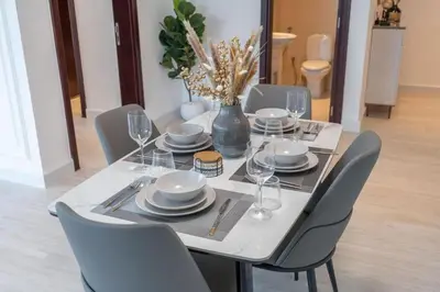 a dining room table with chairs and a vase on it at Luxury 2BHK in Jumeirah Late Towers JLT 2609 in Dubai