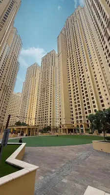 a group of tall buildings with a green field in front at Lux 4BHK in JBR 5 Mins Walk to Beach Sadaf 8 102 in Dubai