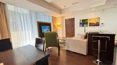 a living room with a couch and a table in a room at Luxury 1BHK located in The Matrix 1-2707 in Dubai