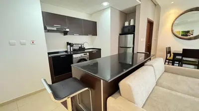 a kitchen with a table and a couch in a room at Luxury 1BHK located in The Matrix 1-2707 in Dubai