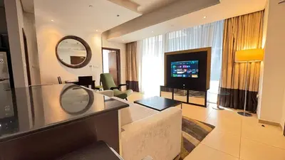 a large living room with a television and a living room at Luxury 1BHK located in The Matrix 1-2707 in Dubai