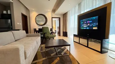 a living room with a couch and a flat screen tv at Luxury 1BHK located in The Matrix 1-2707 in Dubai