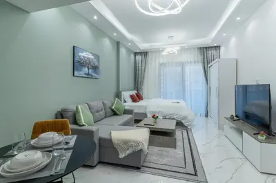 a living room with a couch and a tv at Dubai Marina - Perfect Studio Apartment in Dubai