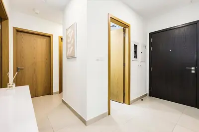 a hallway with two wooden doors and a white wall at FIRST CLASS 2BR Downtown Glam Burj View in Dubai