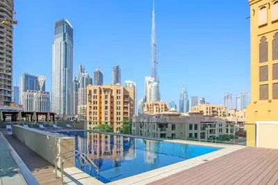 a swimming pool on the roof of a building with a city skyline at FIRST CLASS 2BR Downtown Glam Burj View in Dubai