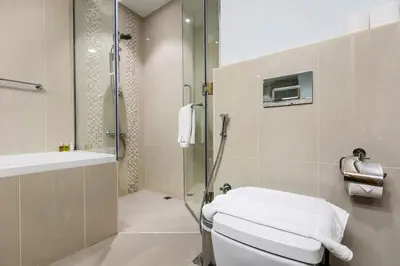 a bathroom with a shower and a toilet and a sink at FIRST CLASS 2BR Downtown Glam Burj View in Dubai