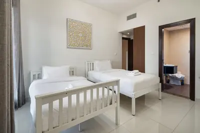 a bedroom with two beds and a mirror at Bright 2BR Sports City Near Miracle GardenParks in Dubai