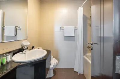 a bathroom with a sink and a toilet and a mirror at Bright 2BR Sports City Near Miracle GardenParks in Dubai