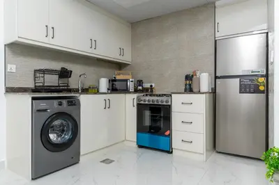 a kitchen with a washing machine and a washer at Dubai Marina - 1BHK Modernistic Apartment in Dubai