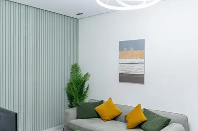 a living room with a couch with yellow and green pillows at Dubai Marina - 1BHK Modernistic Apartment in Dubai