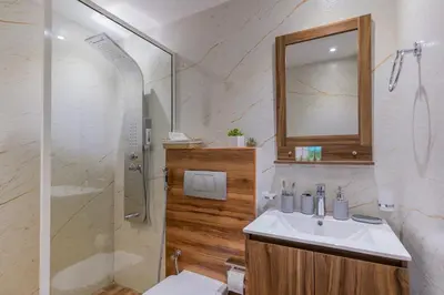 a bathroom with a sink and a shower with a mirror at Dubai Marina - 1BHK Modernistic Apartment in Dubai