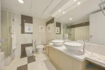 a bathroom with two sinks and two toilets at Plush Winter Stay 1BR Park Tower DIFC & Museum in Dubai