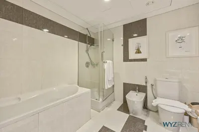 a bathroom with a tub and a toilet and a sink at Plush Winter Stay 1BR Park Tower DIFC & Museum in Dubai