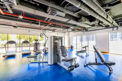 a gym with several treadmills and a blue floor at Vogue Downtown Bellevue Towers near Burj Khalifa and Dubai Mall, One Bedroom Apartment with Balcony and City View, Full Access to all Amenities in Dubai
