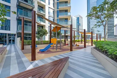 a playground with a slide and a swing at Vogue Downtown Bellevue Towers near Burj Khalifa and Dubai Mall, One Bedroom Apartment with Balcony and City View, Full Access to all Amenities in Dubai