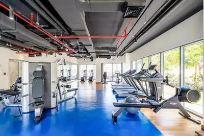 a gym with a bunch of treadms and machines at Vogue Downtown Bellevue Towers near Burj Khalifa and Dubai Mall, One Bedroom Apartment with Balcony and City View, Full Access to all Amenities in Dubai
