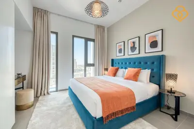 a bedroom with a blue bed and a large window at Keysplease Great Family 2 BR Apt, Townsquare in Dubai