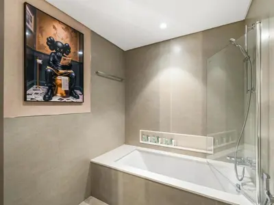 a bathroom with a tub and a painting of a mouse at 51st Floor Sea and Skyline Views LUXE 1BR in Dubai