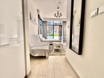 a living room with a couch and a mirror at Luxury studio appartment in Sabkhah